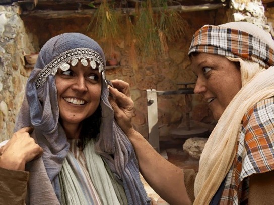 A woman wearing a headscarf decorated with coins